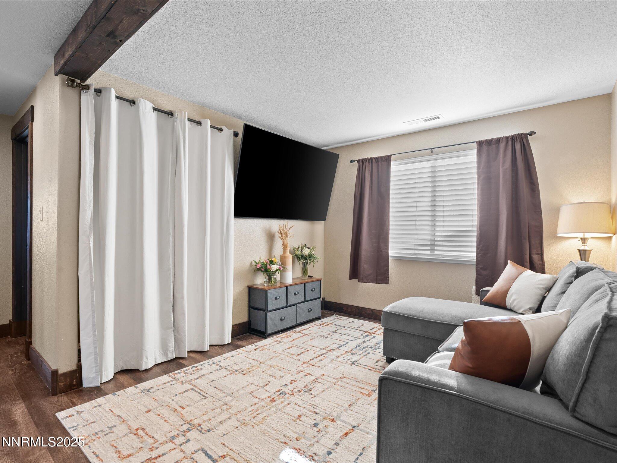 7227 Heatherwood Drive Reno, NV 89523 - Photo 34 of 55 a bedroom with furniture and a flat screen tv