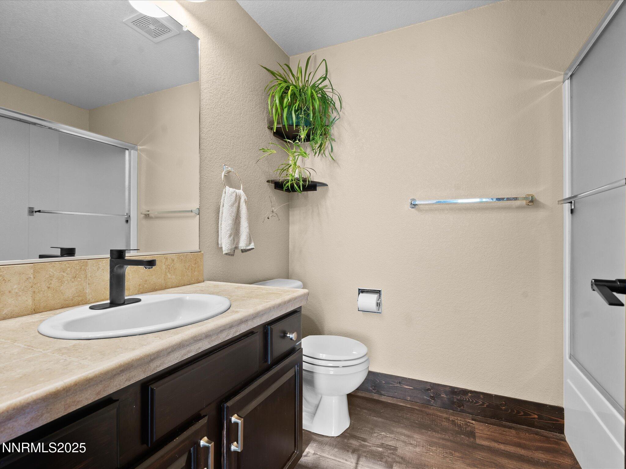 7227 Heatherwood Drive Reno, NV 89523 - Photo 42 of 55 a bathroom with a granite countertop sink a toilet and with mirror