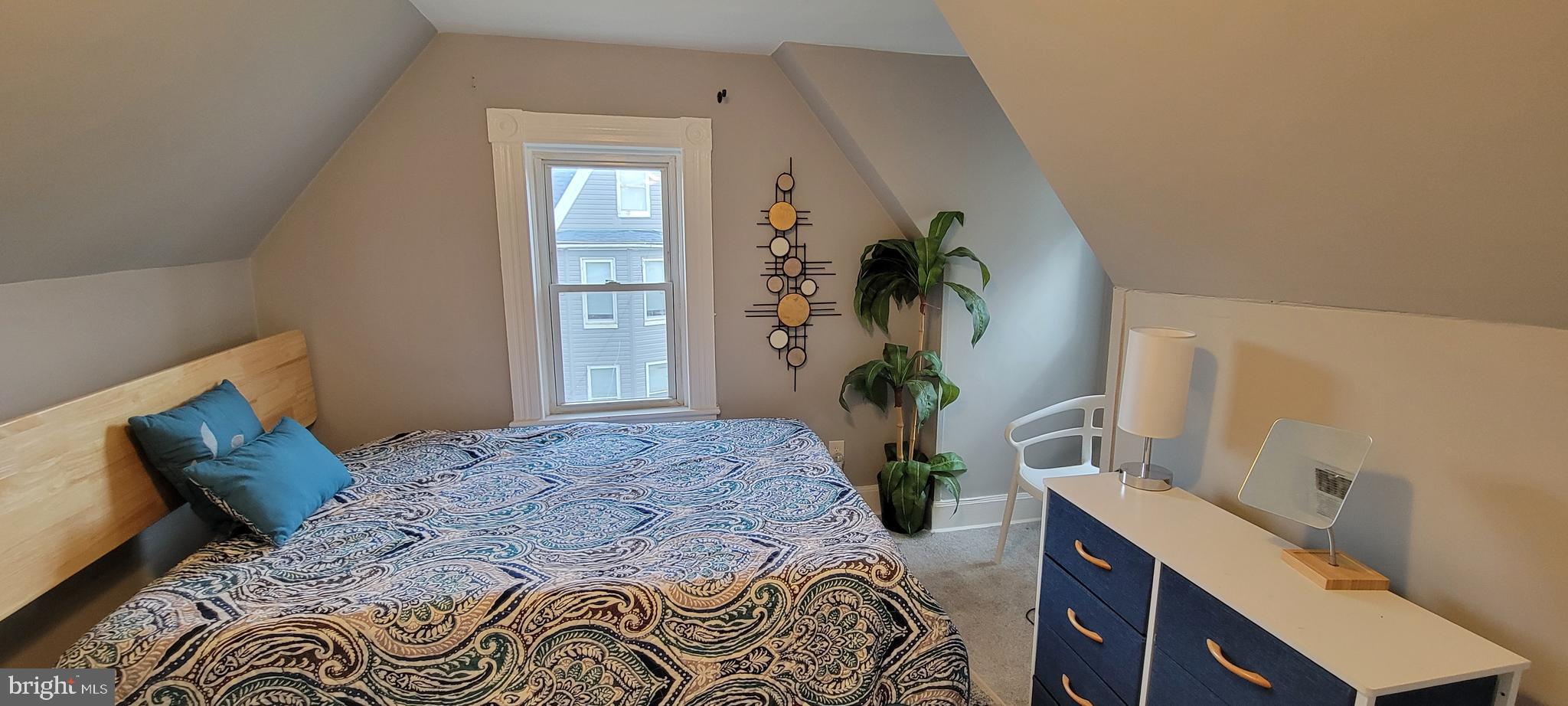 4002 Belvieu Avenue, Unit 3 Baltimore, MD 21215 - Photo 4 of 10 a bedroom with a bed table and a mirror