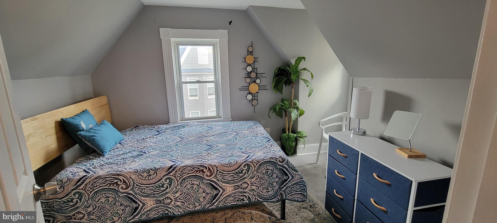 4002 Belvieu Avenue, Unit 3 Baltimore, MD 21215 - Photo 5 of 10 a bedroom with a bed and a potted plant