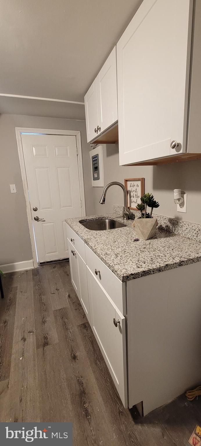 4002 Belvieu Avenue, Unit 3 Baltimore, MD 21215 - Photo 9 of 10 a kitchen with granite countertop a sink a stove and cabinets