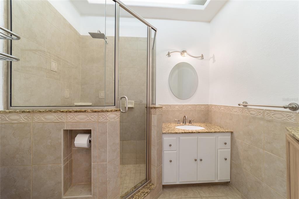 5721 Southwest 31st Street Ocala, FL 34474 - Photo 24 of 41 a bathroom with a granite countertop sink a mirror and a shower