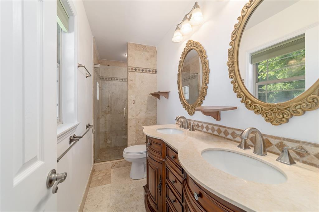 5721 Southwest 31st Street Ocala, FL 34474 - Photo 26 of 41 a bathroom with a granite countertop toilet a sink and a mirror