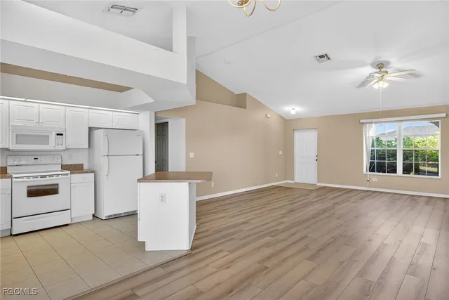 a kitchen with a stove a refrigerator and white cabinets