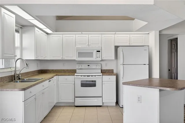 a kitchen with white cabinets and white appliances
