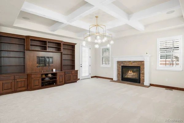 an empty room with fireplace and windows