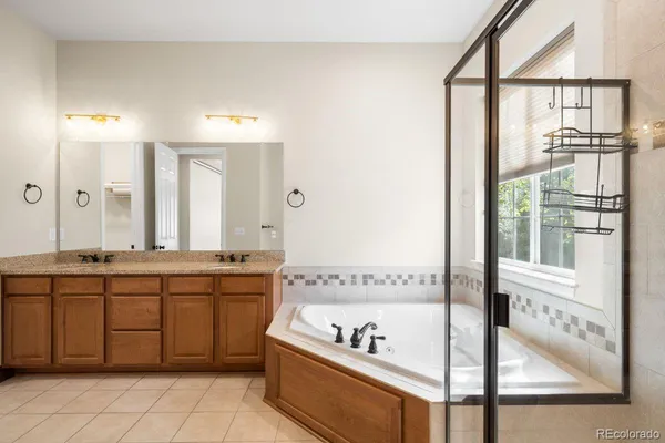 a spacious bathroom with a tub sink and mirror