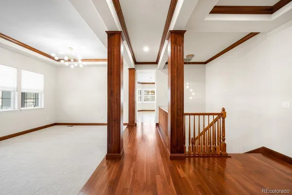 a view of a hallway with wooden floor and staircase