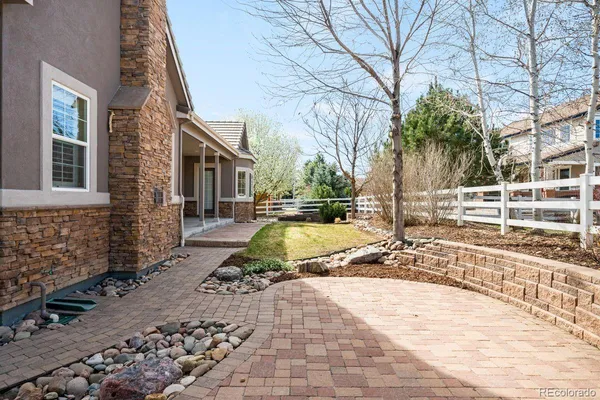 a view of a yard with brick wall and a large tree
