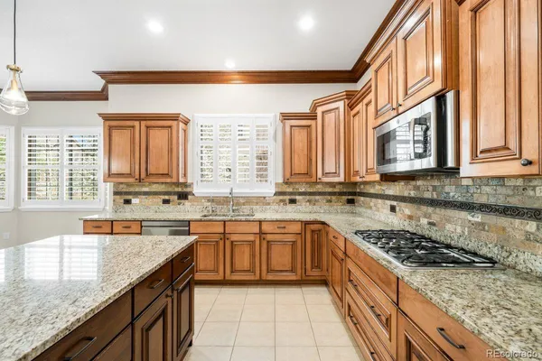 a large kitchen with stainless steel appliances granite countertop a sink stove and cabinets