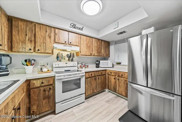 a kitchen with stainless steel appliances granite countertop a refrigerator sink and cabinets