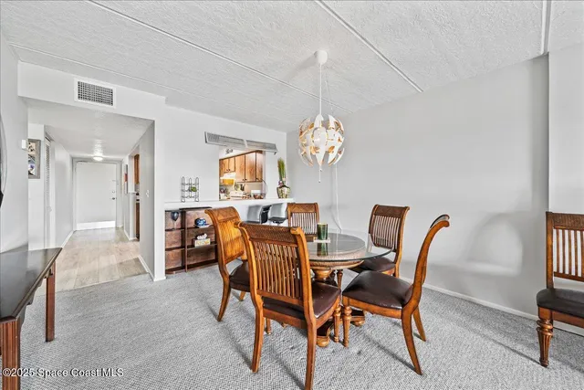 a view of a dining room with furniture and a chandelier
