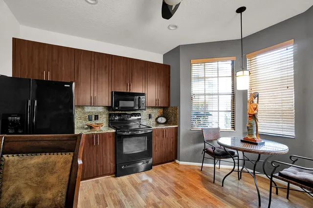 a kitchen with stainless steel appliances wooden floor dining table and chairs