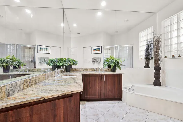 a bathroom with a granite countertop sink a bathtub and shower