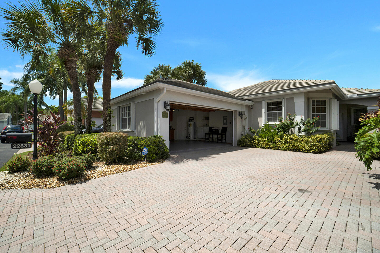 22831 Windsor Wood Court Boca Raton, FL 33433 - Photo 4 of 48 a front view of a house with a yard and potted plants