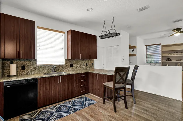a kitchen with granite countertop wooden floors cabinets a dining table and chairs