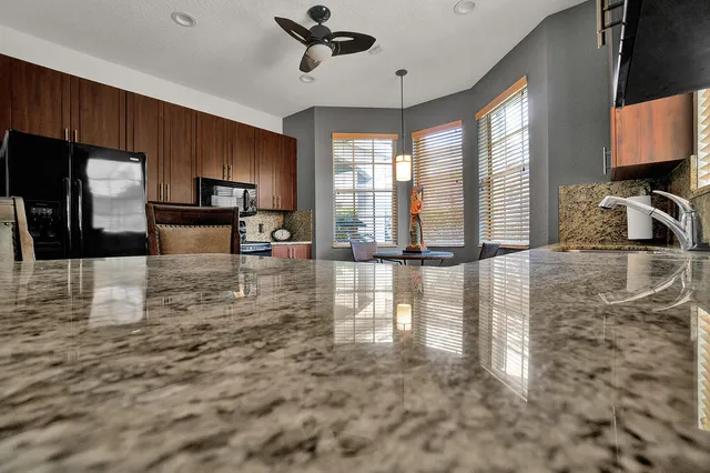 a kitchen with granite countertop a stove a sink and a microwave