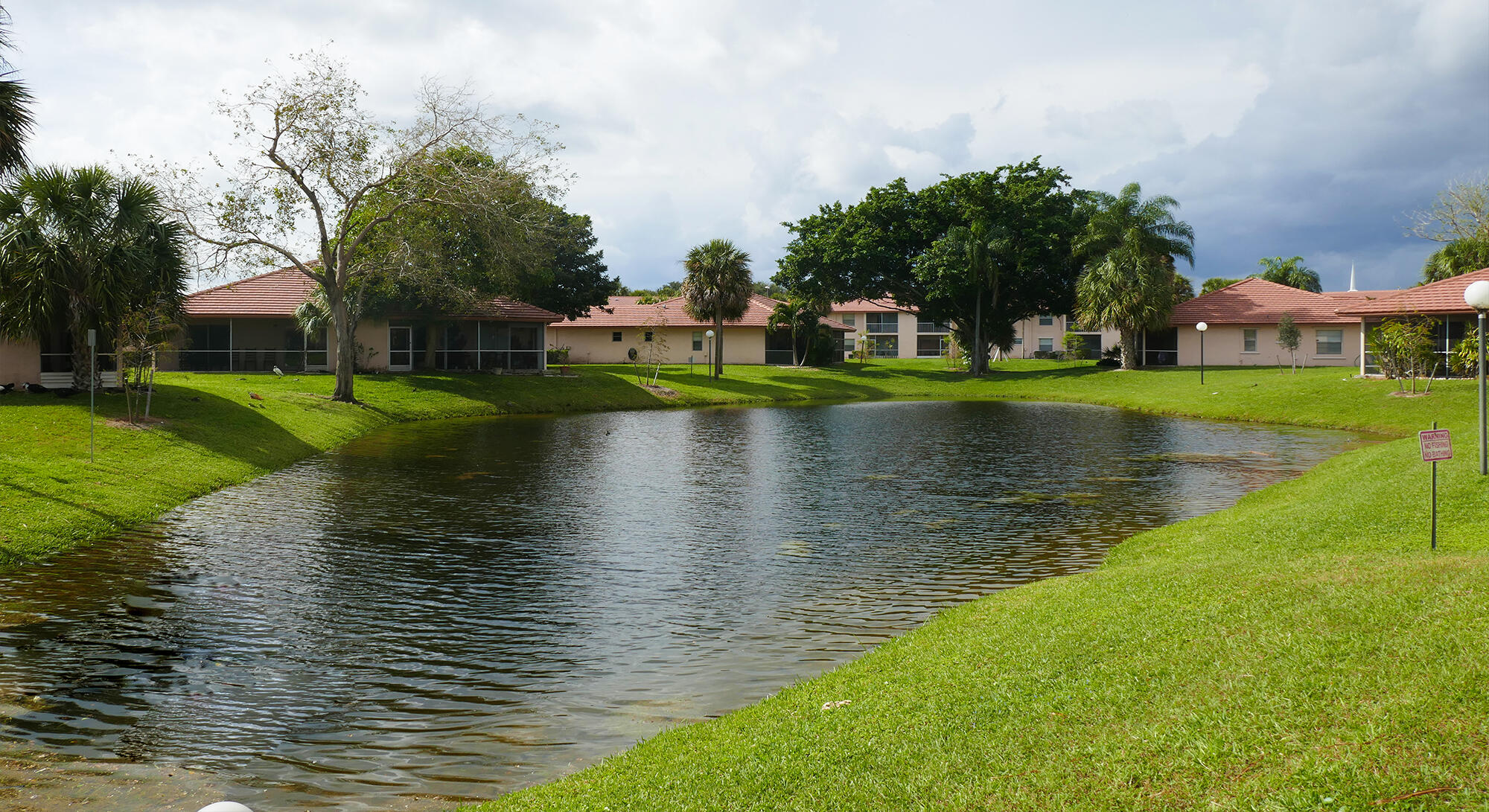 9861 Three Lakes Circle Boca Raton, FL 33428 - Photo 9 of 21 a view of a lake with a yard and large trees