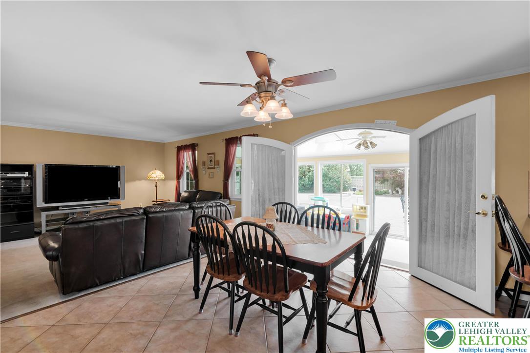 3830 McIntosh Drive Orefield, PA 18069 - Photo 8 of 36 a dining room with furniture a flat screen tv and a large window