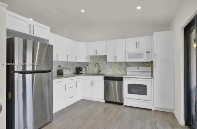 a kitchen with a refrigerator sink and cabinets