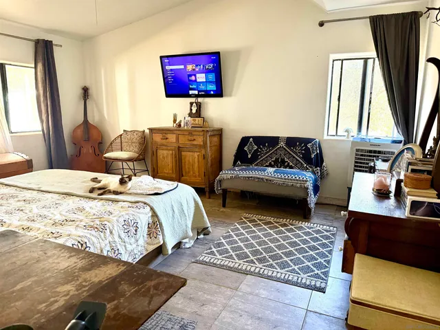 a bedroom with a bed and a couch next to a window