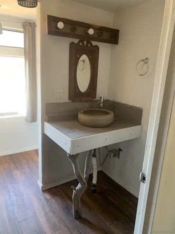 a bathroom with a granite countertop sink and a mirror