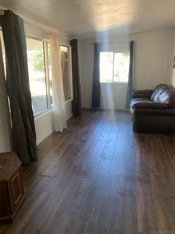 a living room with hardwood floor and a window