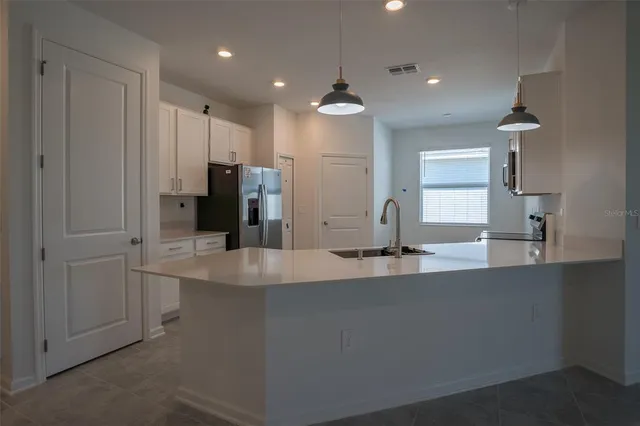a view of a kitchen with a sink and refrigerator