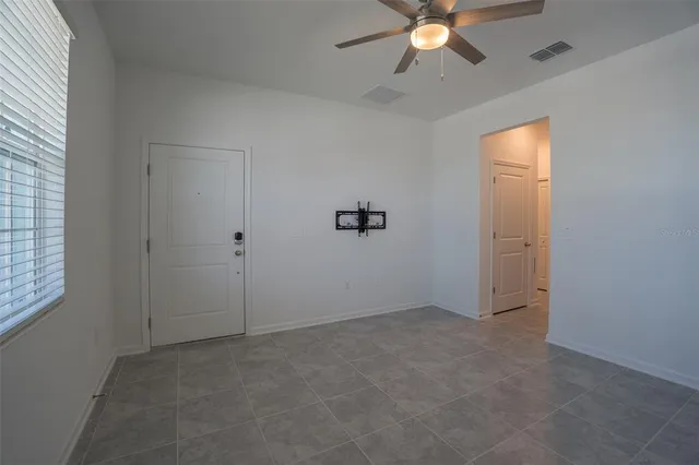 an empty room with closet and a chandelier fan