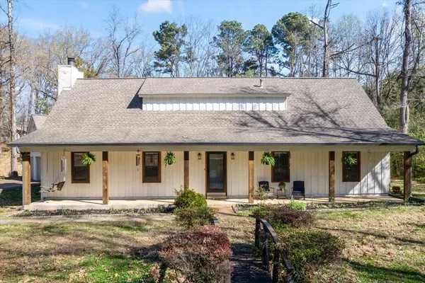 a view of a house with backyard and trees