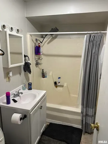 a bathroom with a sink and mirror with bathtub