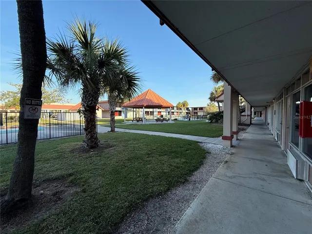a row of palm trees in front of a house