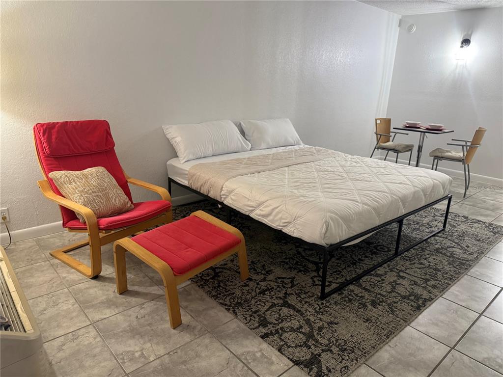 43420 Highway 27, Unit 150 Davenport, FL 33837 - Photo 6 of 8 a bedroom with a bed a chair and a potted plant