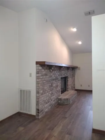 an empty room with wooden floor and fireplace