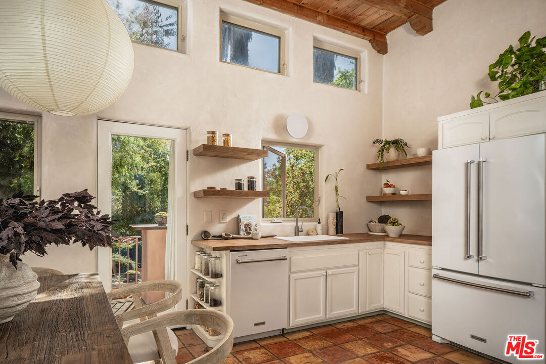 3450 Thacher Road Ojai, CA 93023 - Photo 8 of 33 a kitchen with a refrigerator and white cabinets