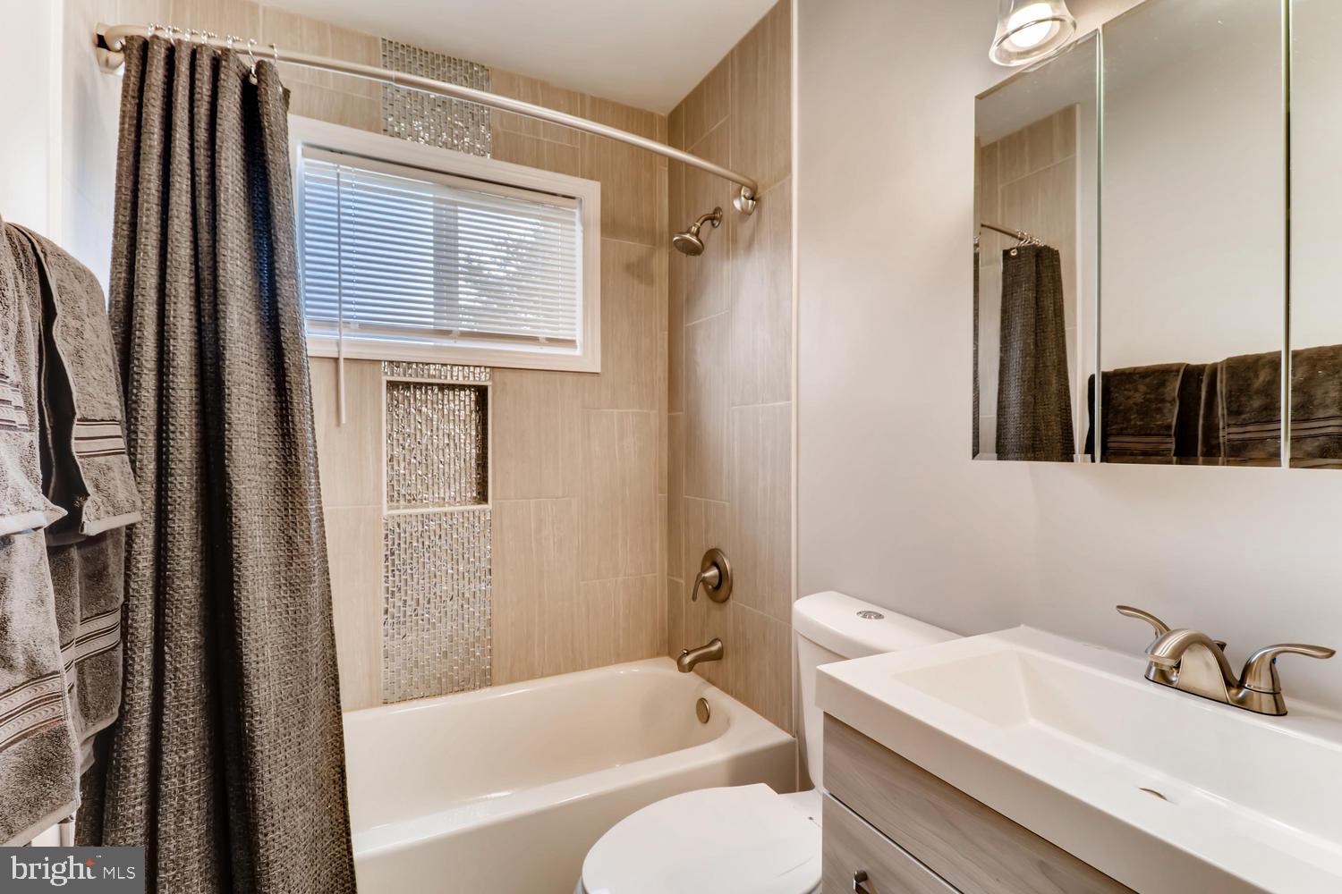 3413 Kimble Road Windsor Mill, MD 21244 - Photo 12 of 28 a bathroom with a sink a mirror and a bathtub