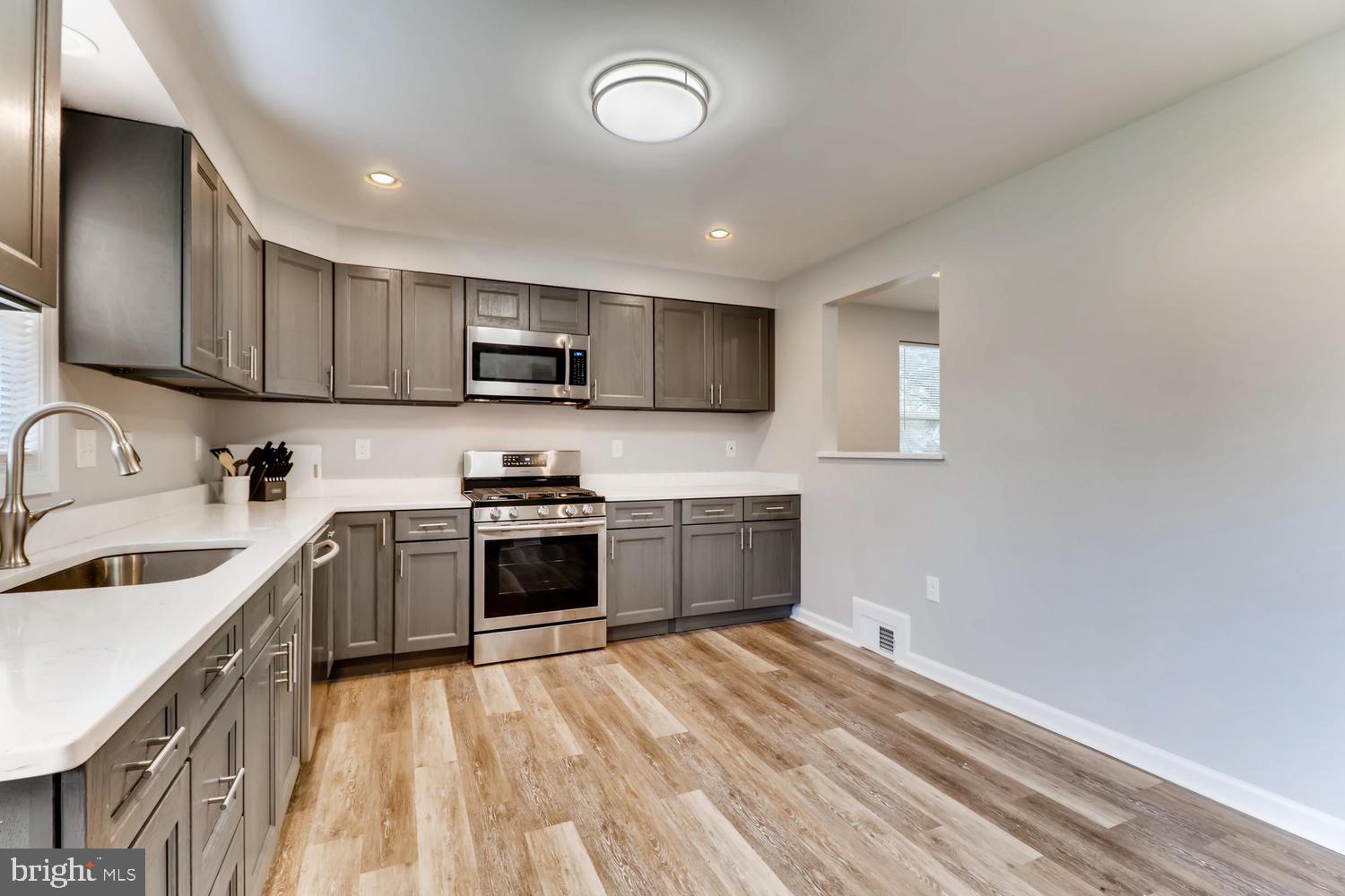 3413 Kimble Road Windsor Mill, MD 21244 - Photo 7 of 28 a kitchen with granite countertop a sink cabinets and stainless steel appliances