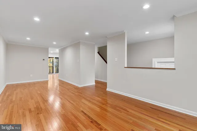 a view of empty room with wooden floor