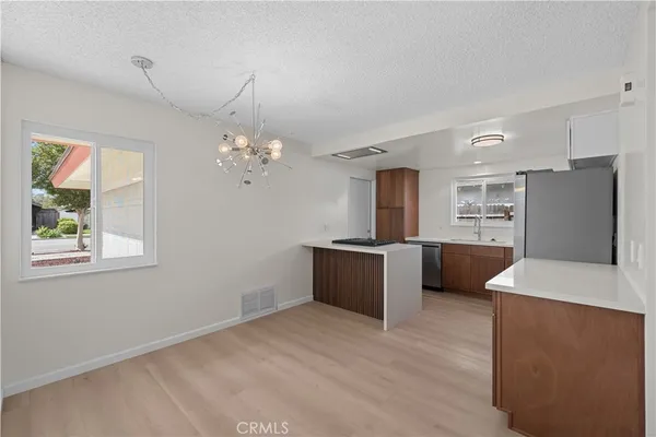 a large kitchen with a refrigerator a sink dishwasher with a dining table and chairs