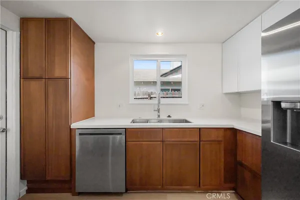 a kitchen with a sink a refrigerator and cabinets