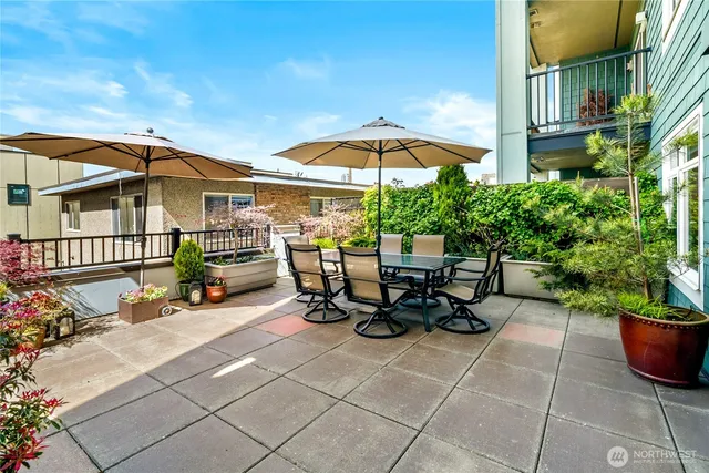 a view of a patio with table and chairs under an umbrella