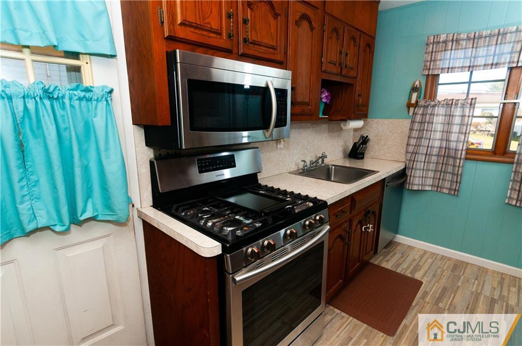 18 Rutgers Road Old Bridge, NJ 08859 - Photo 9 of 30 a kitchen with a stove and a microwave