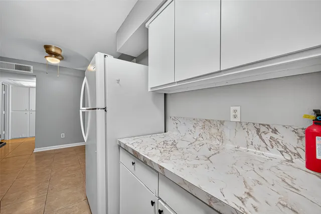 a view of kitchen cabinets and refrigerator
