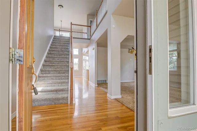 an empty room with windows and chandelier fan