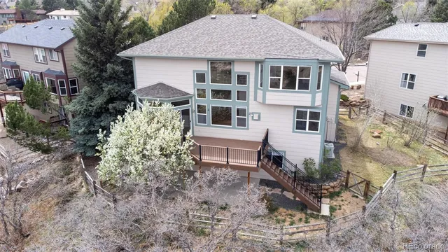 an aerial view of a house with a yard and large tree