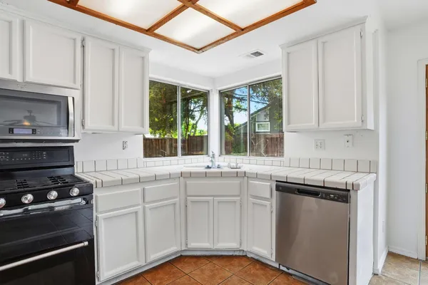 a kitchen with stainless steel appliances granite countertop a stove and a sink