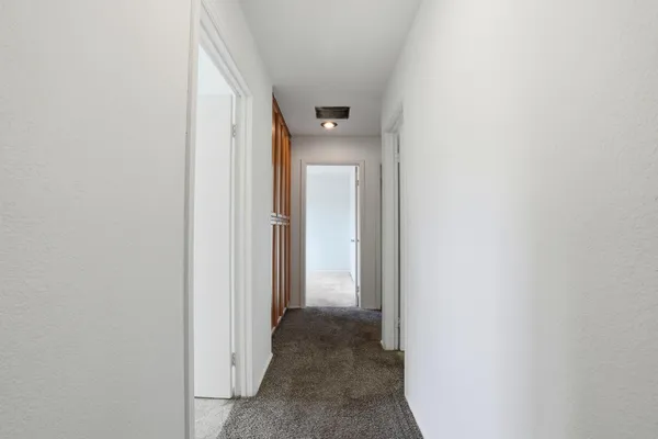 a view of a hallway with wooden cabinets