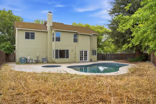 a view of a house with backyard and sitting area