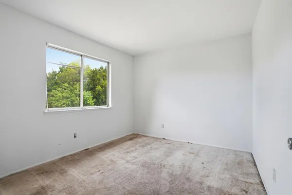 an empty room with windows and closet