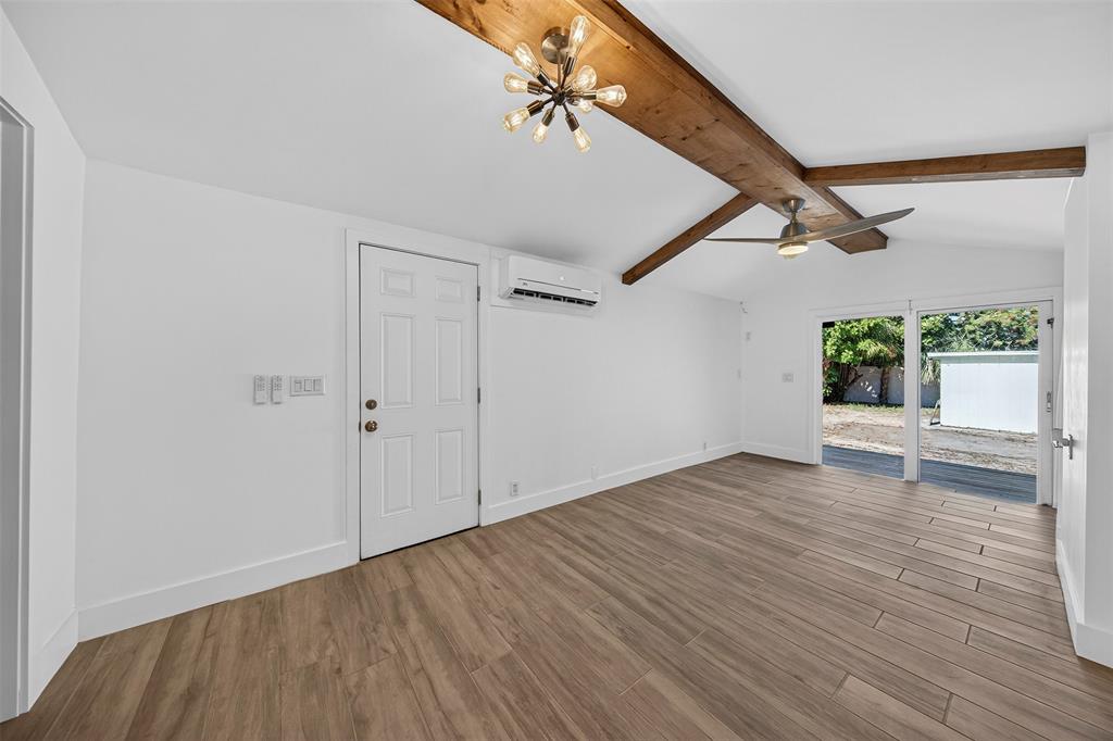 181 Northeast 15th Terrace Boca Raton, FL 33431 - Photo 12 of 51 a view of an empty room with wooden floor and a window